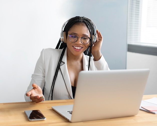 Mittlere Schussfrau, die mit Laptop arbeitet