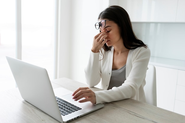 Mittlere Schussfrau, die mit Laptop arbeitet