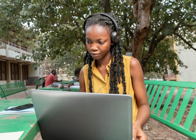 Mittlere Schussfrau, die mit Laptop studiert