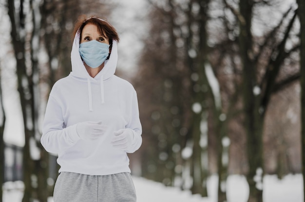 Kostenloses Foto mittlere schussfrau, die mit masken läuft