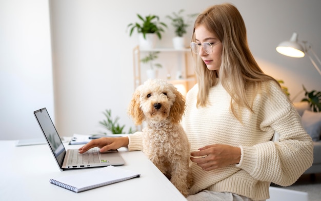 Mittlere Schussfrau, die mit süßem Hund arbeitet