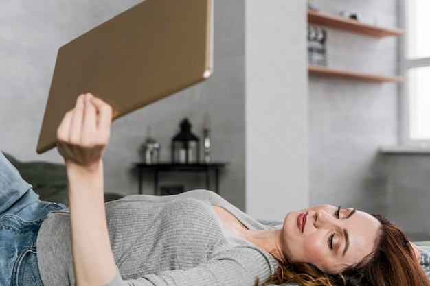 Mittlere Schussfrau, die mit Tablette liegt