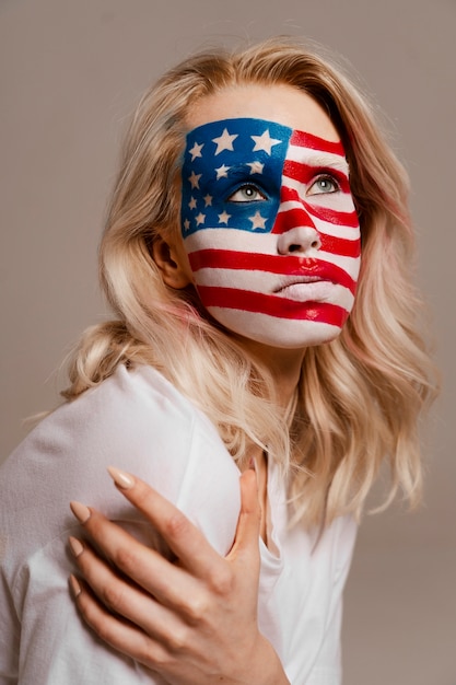 Kostenloses Foto mittlere schussfrau, die mit usa-make-up aufwirft