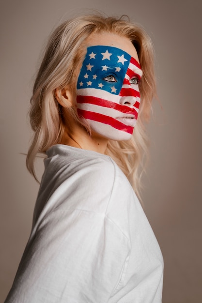 Kostenloses Foto mittlere schussfrau, die mit usa-make-up aufwirft