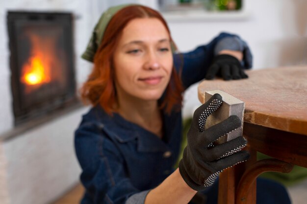 Mittlere Schussfrau, die Möbel wieder herstellt