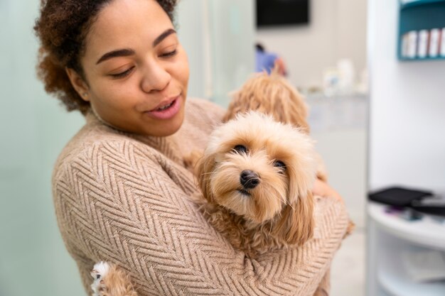 Mittlere Schussfrau, die netten Hund hält