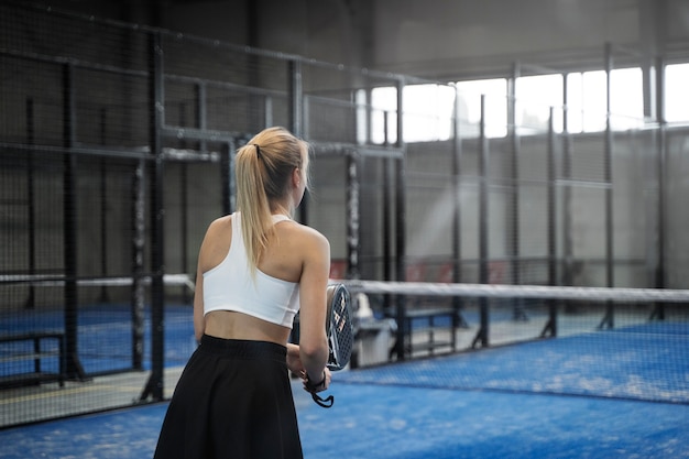 Kostenloses Foto mittlere schussfrau, die paddle-tennis spielt