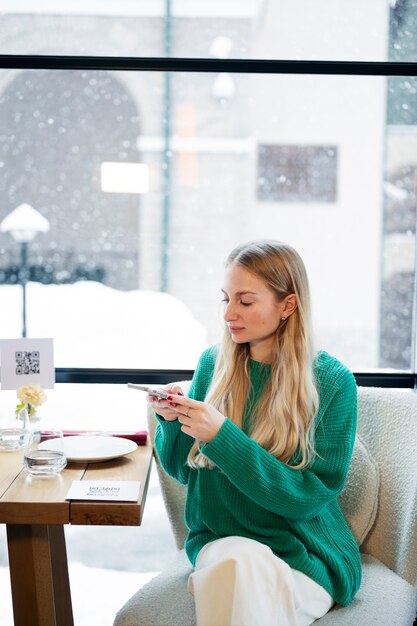 Mittlere Schussfrau, die QR-Code im Restaurant scannt