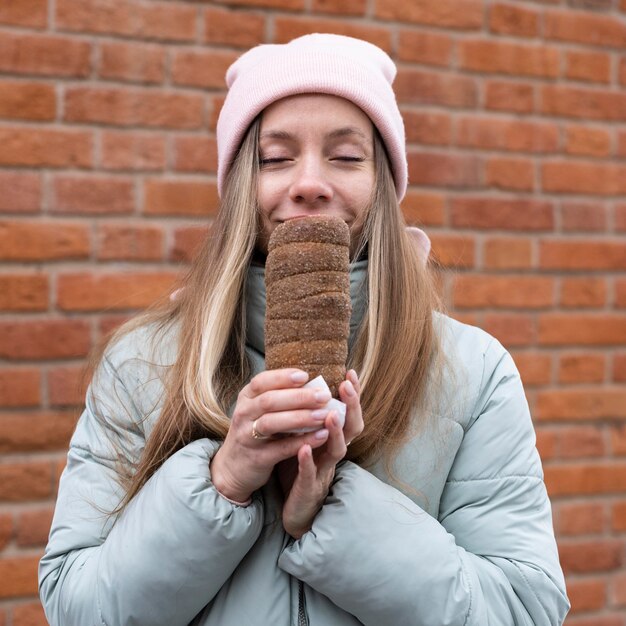 Mittlere Schussfrau, die Schornsteinkuchen hält