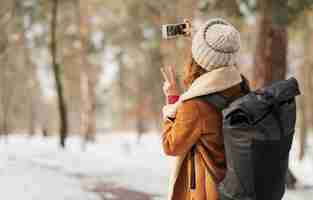 Kostenloses Foto mittlere schussfrau, die selfie draußen nimmt