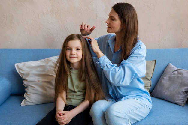 Kostenloses Foto mittlere schussfrau, die sich um mädchen kümmert