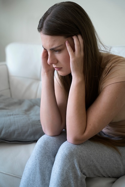 Kostenloses Foto mittlere schussfrau, die sich zu hause sorgen macht