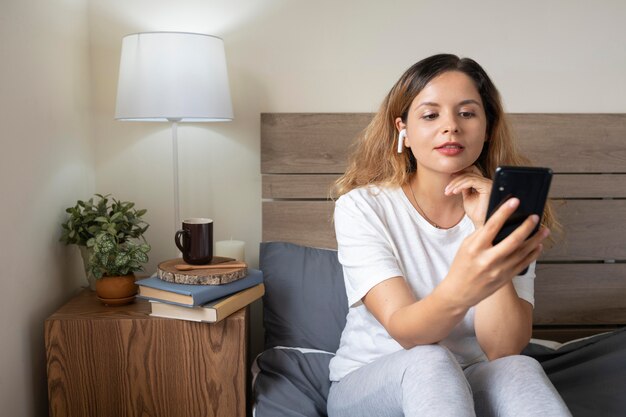 Kostenloses Foto mittlere schussfrau, die smartphone hält