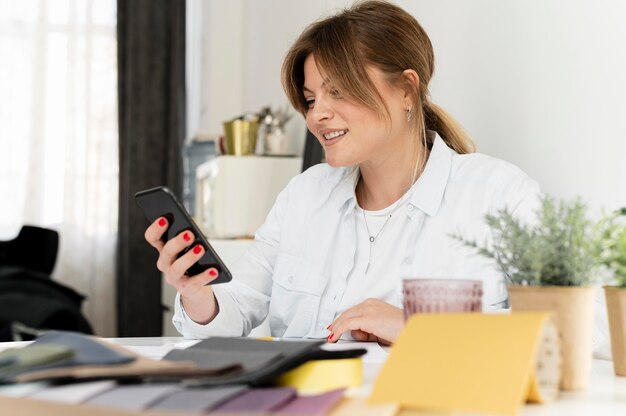 Mittlere Schussfrau, die Smartphone hält