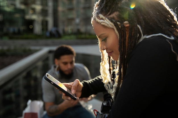 Kostenloses Foto mittlere schussfrau, die smartphone hält