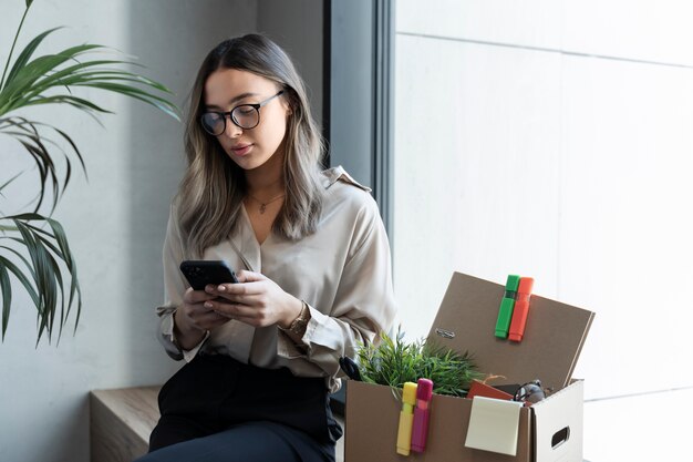 Mittlere Schussfrau, die Smartphone hält