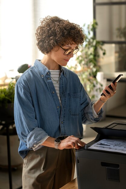 Mittlere Schussfrau, die Smartphone hält