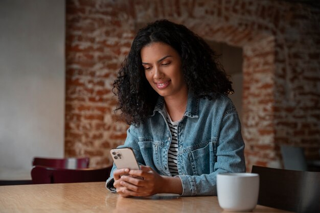 Mittlere Schussfrau, die Smartphone hält