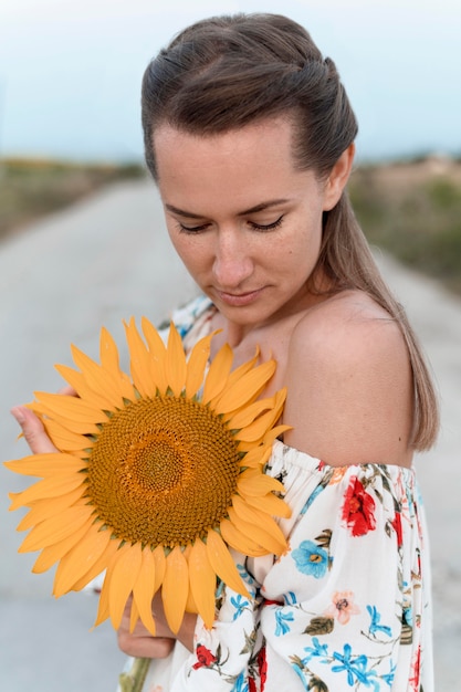 Mittlere Schussfrau, die Sonnenblume betrachtet