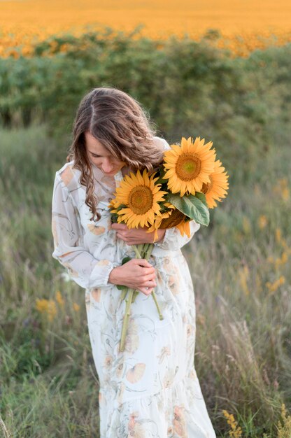 Mittlere Schussfrau, die Sonnenblumen hält