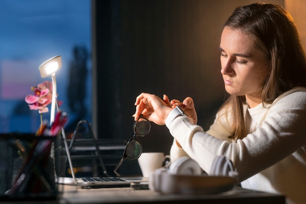 Kostenloses Foto mittlere schussfrau, die spät nachts arbeitet