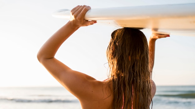 Kostenloses Foto mittlere schussfrau, die surfbrett hält