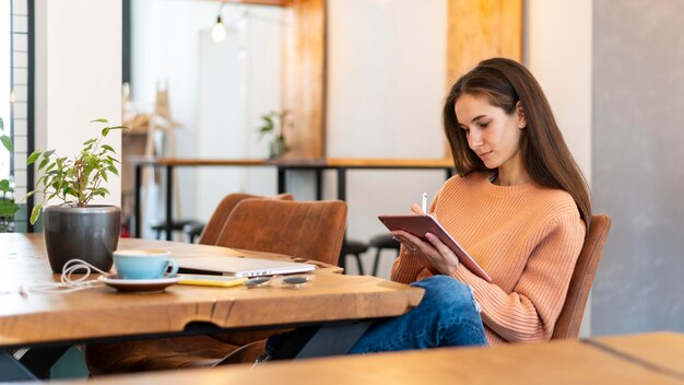 Mittlere Schussfrau, die Tablette hält