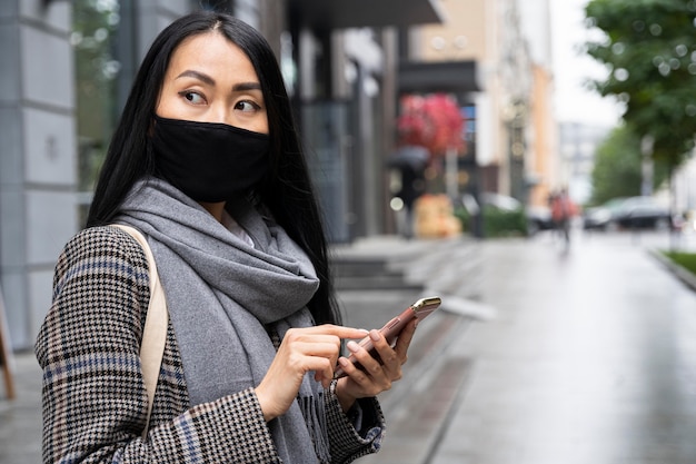 Kostenloses Foto mittlere schussfrau, die telefon hält