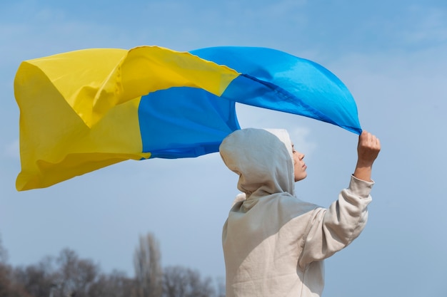 Mittlere Schussfrau, die ukrainische Flagge hält