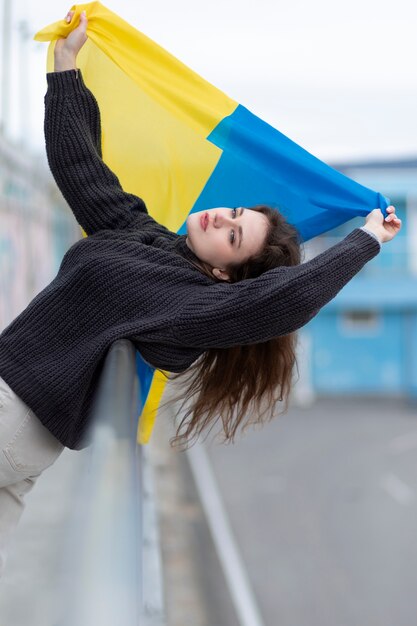 Mittlere Schussfrau, die ukrainische Flagge hält