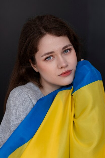 Mittlere Schussfrau, die ukrainische Flagge hält