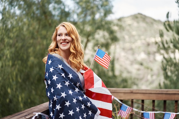 Mittlere schussfrau, die usa-flagge trägt