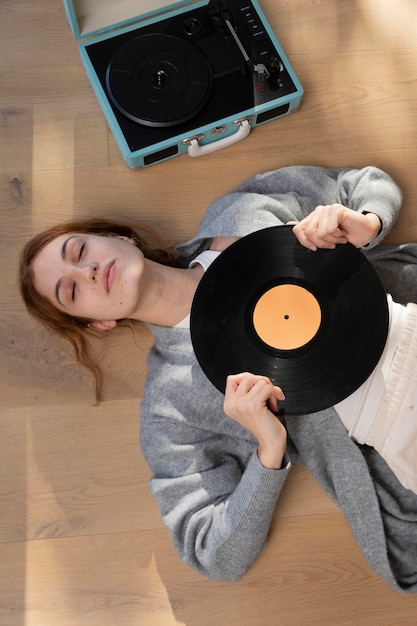 Kostenloses Foto mittlere schussfrau, die vinyl hält