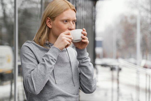 Mittlere Schussfrau, die von der Tasse trinkt