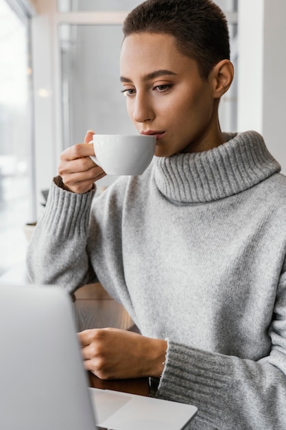 Mittlere Schussfrau, die von der Tasse trinkt