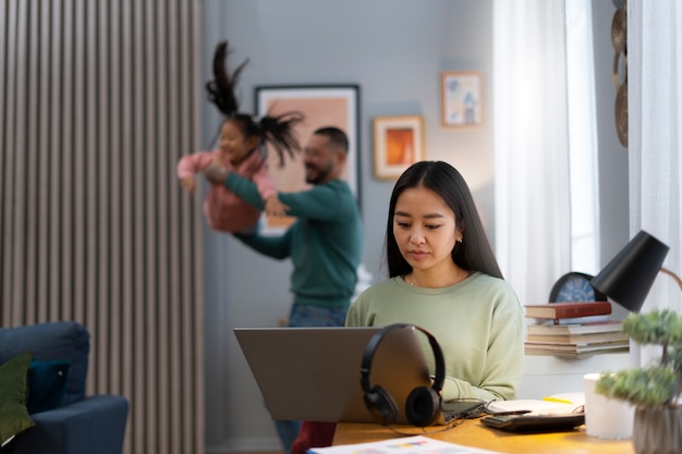 Kostenloses Foto mittlere schussfrau, die von zu hause aus arbeitet