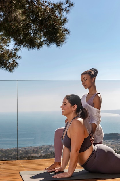 Mittlere Schussfrau, die Yoga auf Matte tut