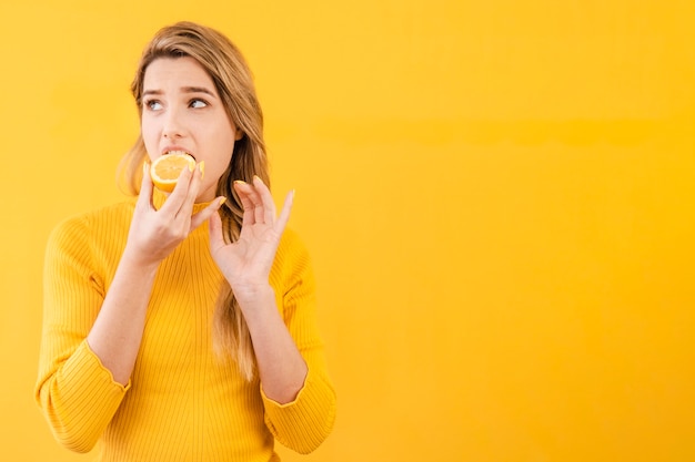 Kostenloses Foto mittlere schussfrau, die zitrusfrüchte isst