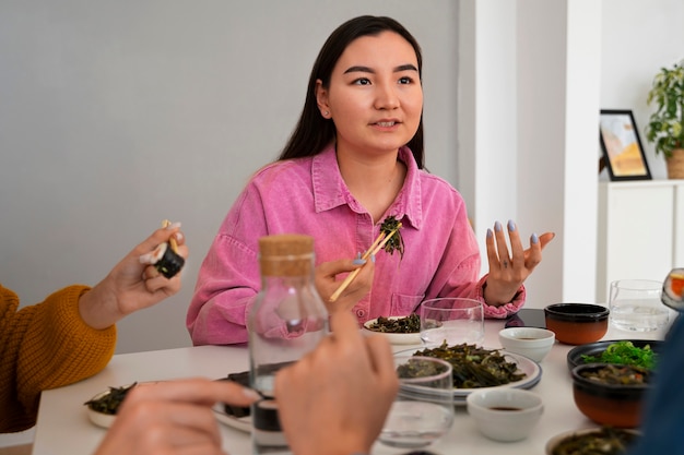 Kostenloses Foto mittlere schussfrau, die zu hause isst