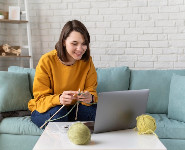 Mittlere Schussfrau, die zu Hause strickt