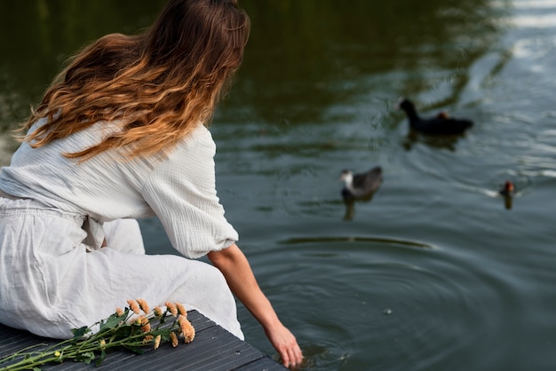 Kostenloses Foto mittlere schussfrau durch den see