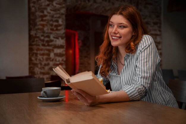 Mittlere Schussfrau mit Buch im Café