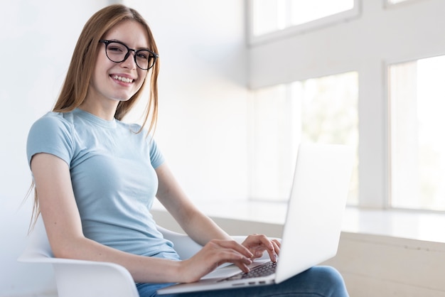 Kostenloses Foto mittlere schussfrau mit den gläsern, die an ihrem laptop arbeiten