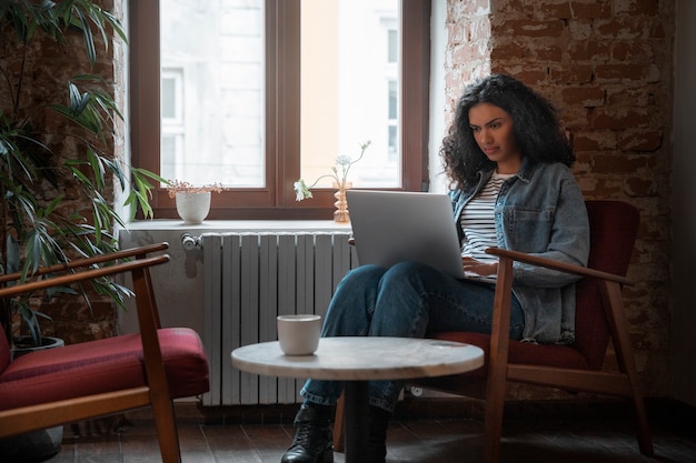 Mittlere Schussfrau mit Laptop im Café