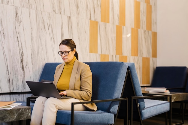 Kostenloses Foto mittlere schussfrau mit laptop