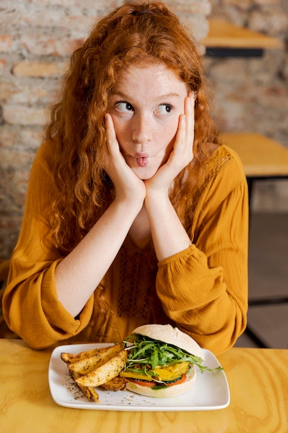 Kostenloses Foto mittlere schussfrau mit leckerem essen