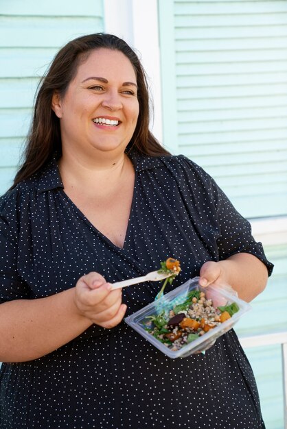 Kostenloses Foto mittlere schussfrau mit leckerem essen