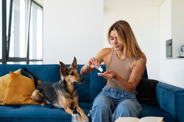 Kostenloses Foto mittlere schussfrau mit nettem hund zu hause