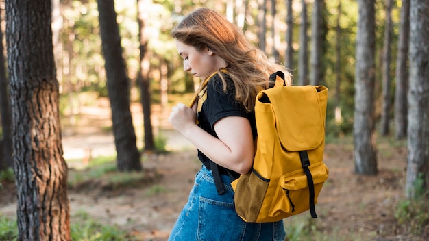 Mittlere Schussfrau mit Rucksack im Wald