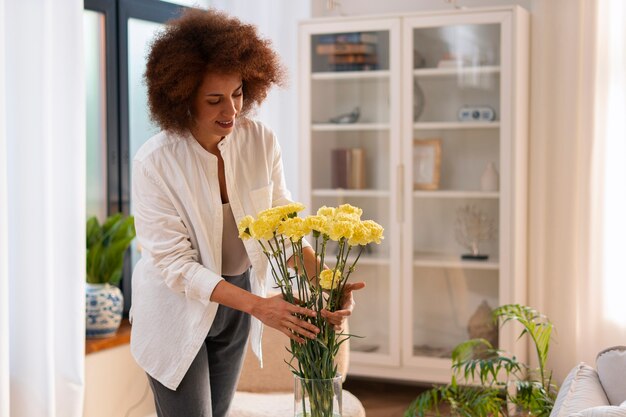 Kostenloses Foto mittlere schussfrau mit schönen blumen